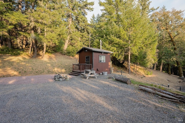 view of outbuilding featuring a forest view and an outbuilding