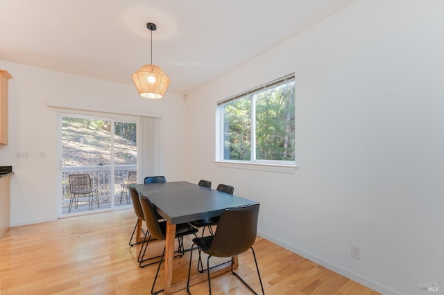 dining area with baseboards and light wood-type flooring