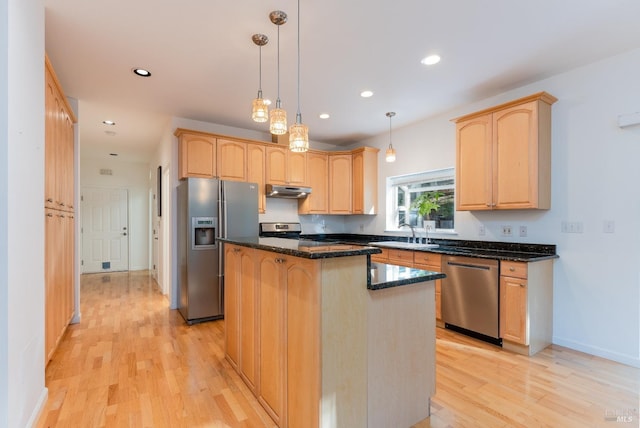 kitchen with a center island, light wood-style floors, stainless steel appliances, and light brown cabinets