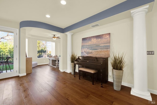 miscellaneous room with dark wood-type flooring, ceiling fan, and decorative columns