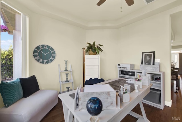 office space with dark hardwood / wood-style floors, ceiling fan, and a tray ceiling