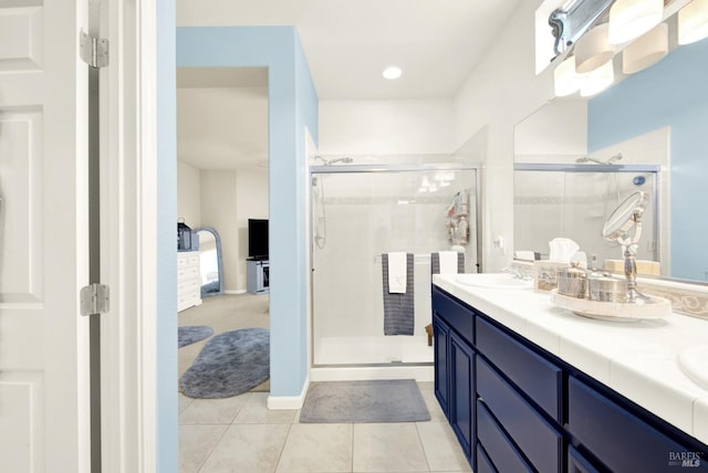 bathroom featuring tile patterned flooring, vanity, and a shower with shower door