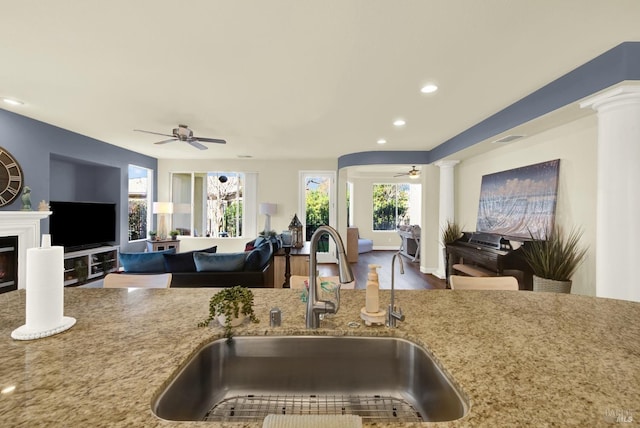 kitchen featuring decorative columns, plenty of natural light, sink, and ceiling fan