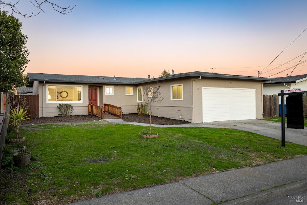 ranch-style home featuring a yard and a garage