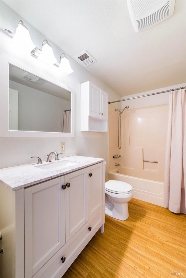 full bathroom featuring vanity, hardwood / wood-style floors, shower / tub combo with curtain, and toilet