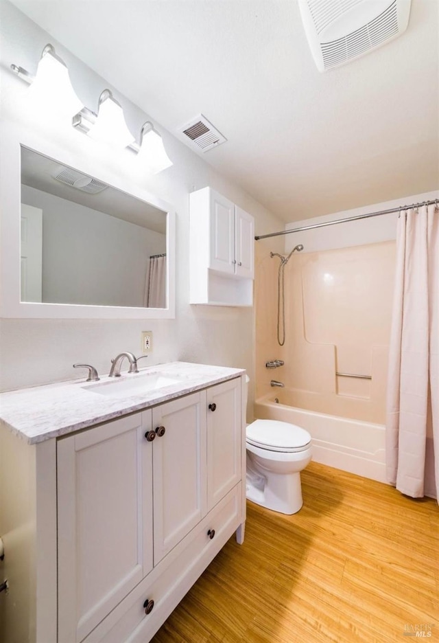 full bathroom with hardwood / wood-style flooring, vanity, toilet, and shower / bath combo with shower curtain