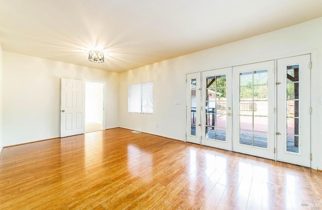 spare room with french doors and light hardwood / wood-style flooring