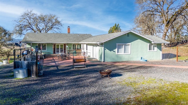 rear view of property with a fire pit, french doors, and a deck