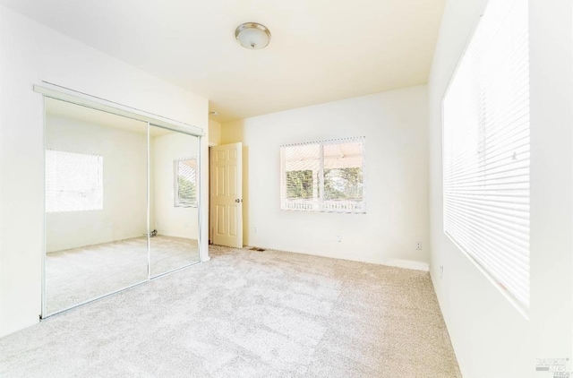 unfurnished bedroom with carpet flooring and a closet