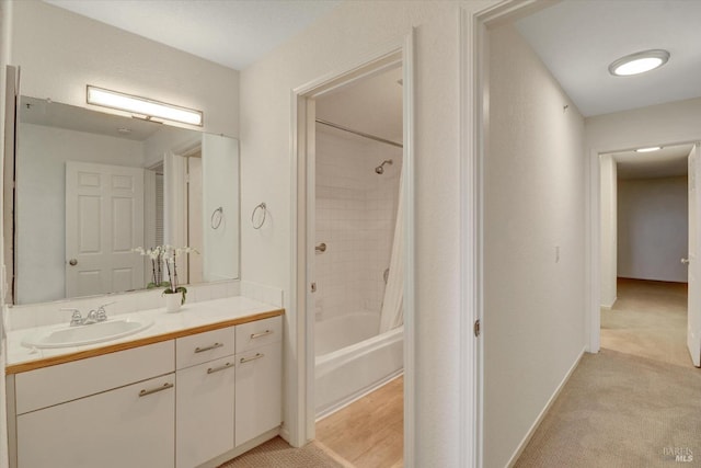 full bath with vanity, baseboards, and shower / bath combo