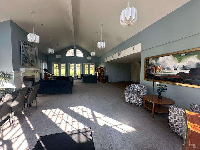 living room with visible vents, beam ceiling, carpet flooring, a glass covered fireplace, and high vaulted ceiling