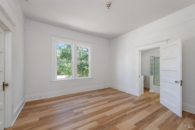 empty room with baseboards and light wood-style flooring