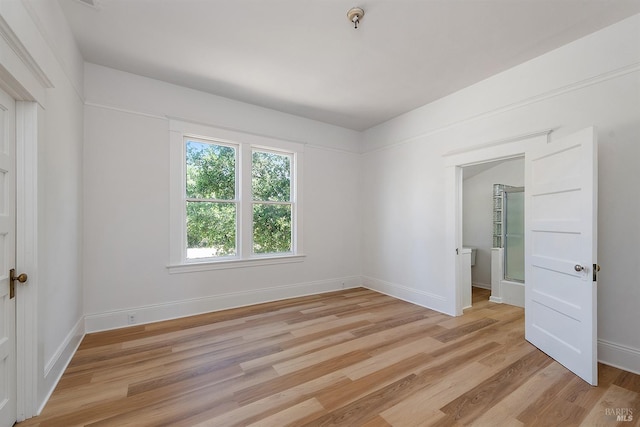 empty room with light wood-type flooring and baseboards