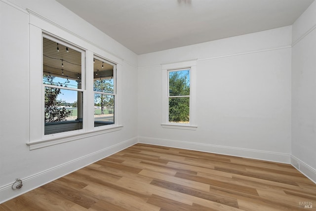 unfurnished room featuring baseboards and light wood-type flooring