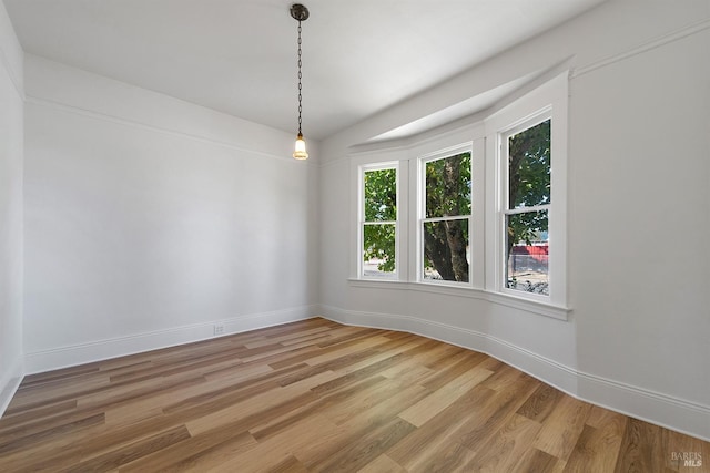 unfurnished dining area featuring light wood finished floors and baseboards