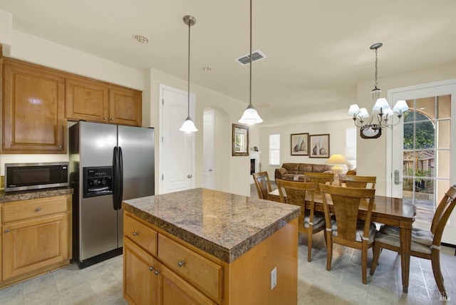 kitchen featuring hanging light fixtures, appliances with stainless steel finishes, a center island, and plenty of natural light