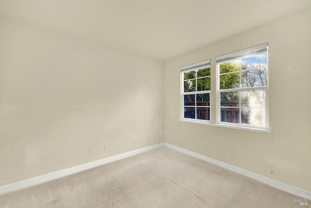 spare room featuring light colored carpet