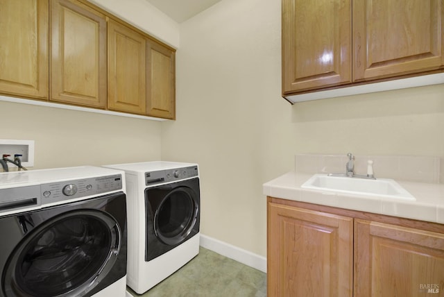 laundry room with separate washer and dryer, sink, and cabinets