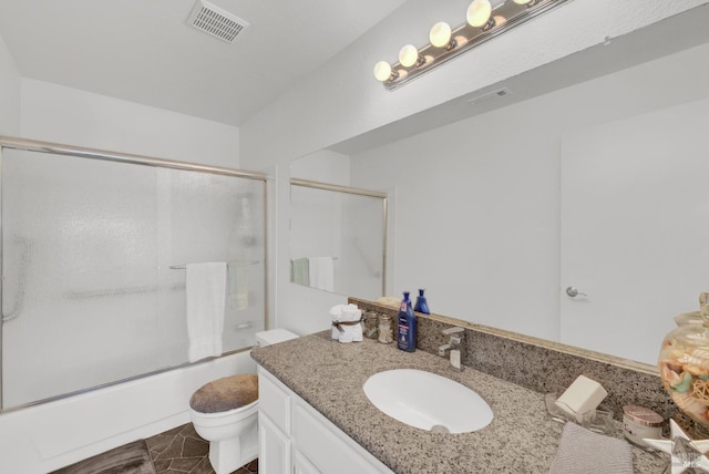 full bathroom featuring vanity, shower / bath combination with glass door, and toilet