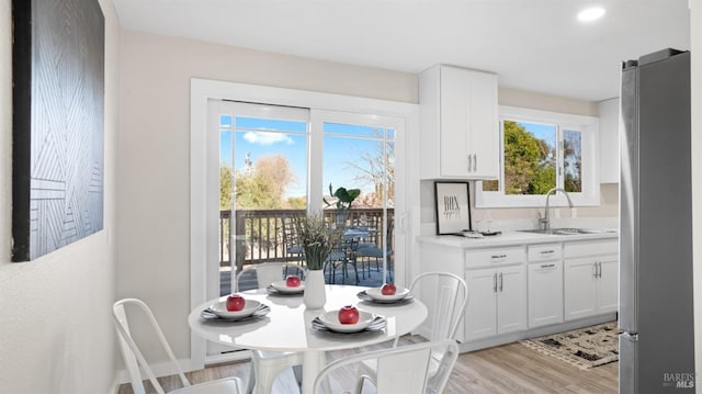 dining space with sink and light hardwood / wood-style floors