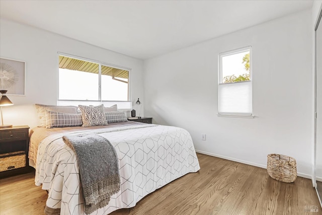 bedroom with baseboards and wood finished floors