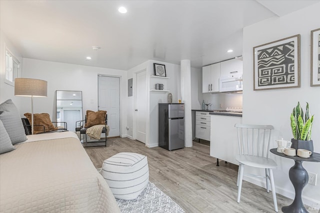 bedroom featuring freestanding refrigerator, baseboards, light wood finished floors, and recessed lighting