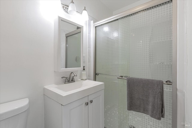 full bathroom featuring toilet, a shower stall, and vanity