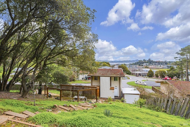 view of yard featuring a shed, an outdoor structure, and fence