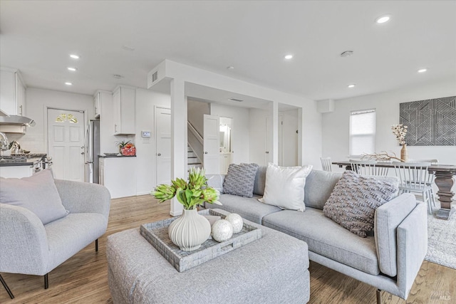 living room featuring stairs, recessed lighting, and wood finished floors