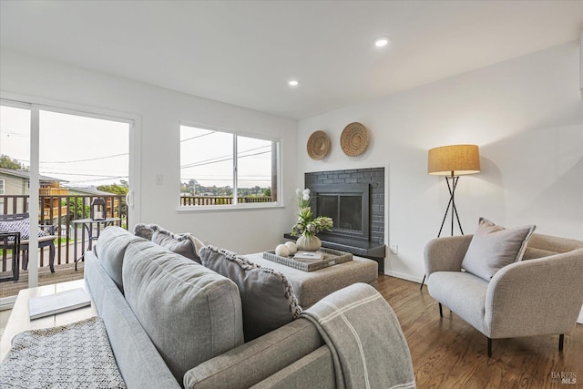 living area with recessed lighting, a fireplace, baseboards, and wood finished floors