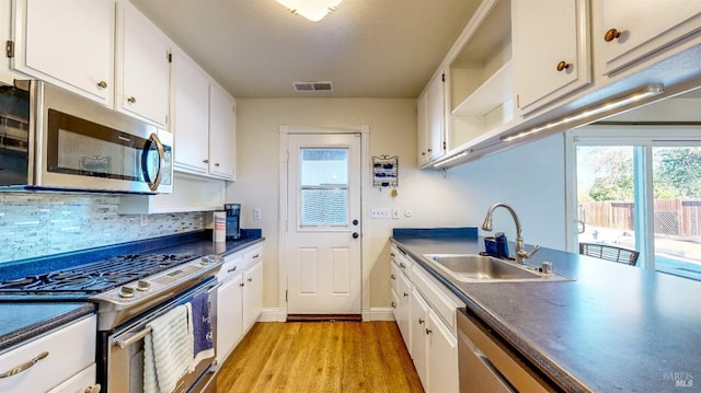 kitchen featuring white cabinetry, appliances with stainless steel finishes, sink, and light hardwood / wood-style flooring