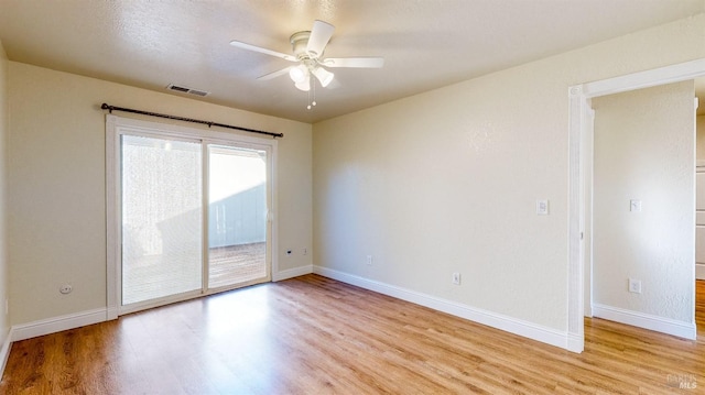 empty room featuring a textured ceiling, ceiling fan, and light hardwood / wood-style flooring