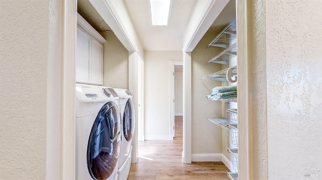 clothes washing area featuring separate washer and dryer and light wood-type flooring