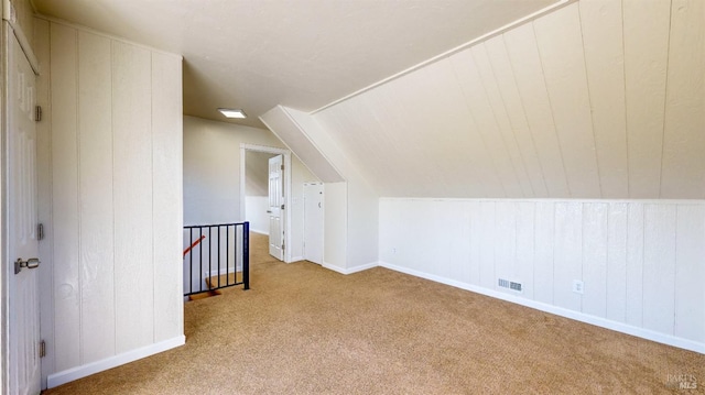 additional living space featuring vaulted ceiling and light carpet