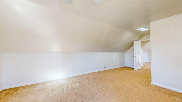 additional living space featuring light colored carpet and lofted ceiling