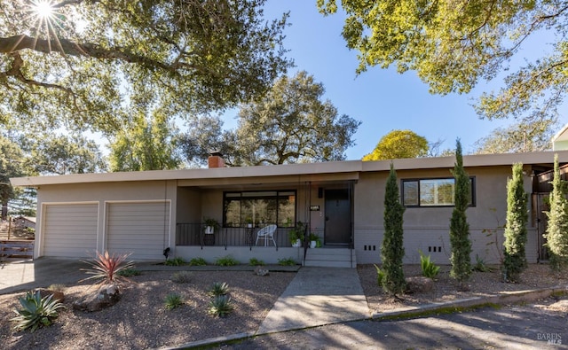 ranch-style house featuring a garage and covered porch