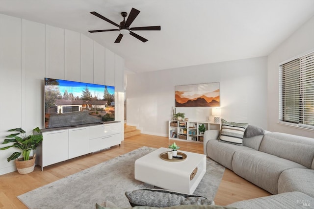 living room featuring vaulted ceiling, ceiling fan, and light wood-type flooring