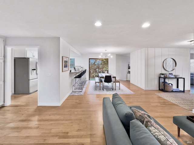 living room featuring a chandelier and light hardwood / wood-style floors