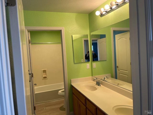 full bathroom featuring vanity, hardwood / wood-style floors,  shower combination, and toilet