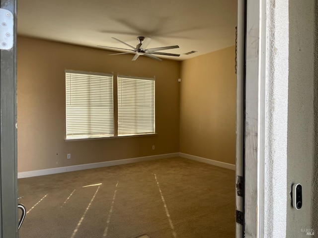 spare room featuring ceiling fan and carpet flooring