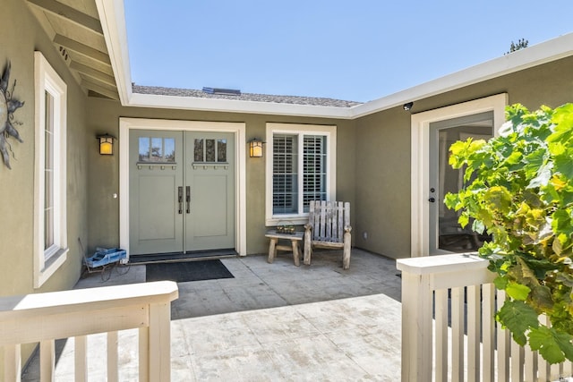 view of exterior entry with a patio and french doors