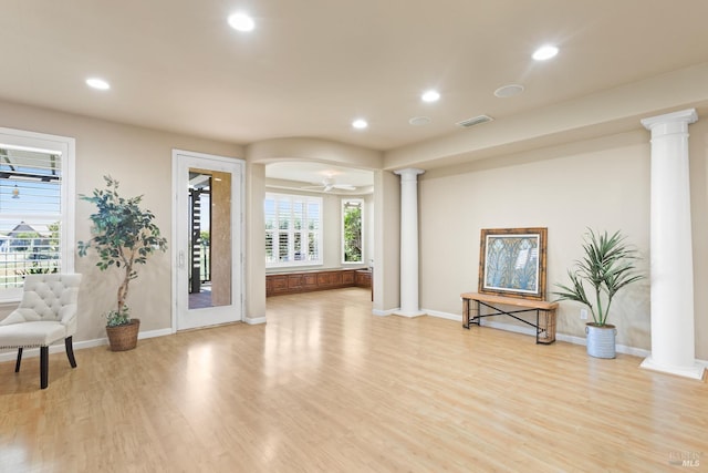 living room with ceiling fan, decorative columns, and light hardwood / wood-style flooring