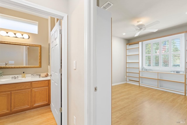 bathroom with ceiling fan, visible vents, wood finished floors, and vanity