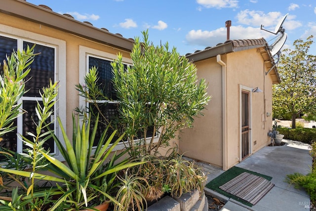 view of side of property with a patio area and stucco siding