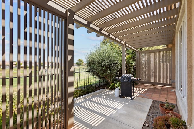 view of patio with fence, grilling area, and a pergola