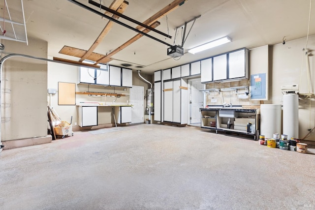 garage featuring strapped water heater, electric panel, and a garage door opener