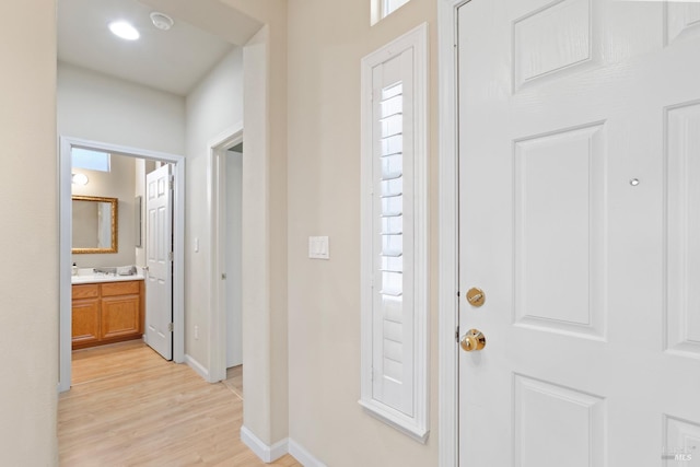 foyer featuring light wood-style flooring and baseboards