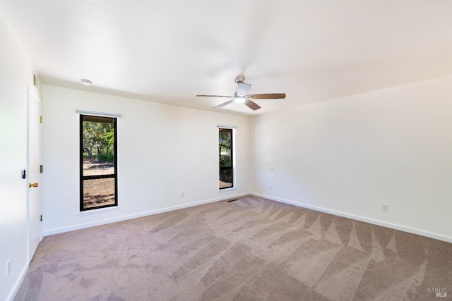 carpeted spare room featuring ceiling fan