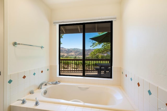 bathroom with a mountain view and tiled bath