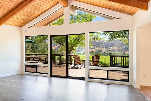 doorway to outside featuring beamed ceiling, wood-type flooring, wooden ceiling, and high vaulted ceiling